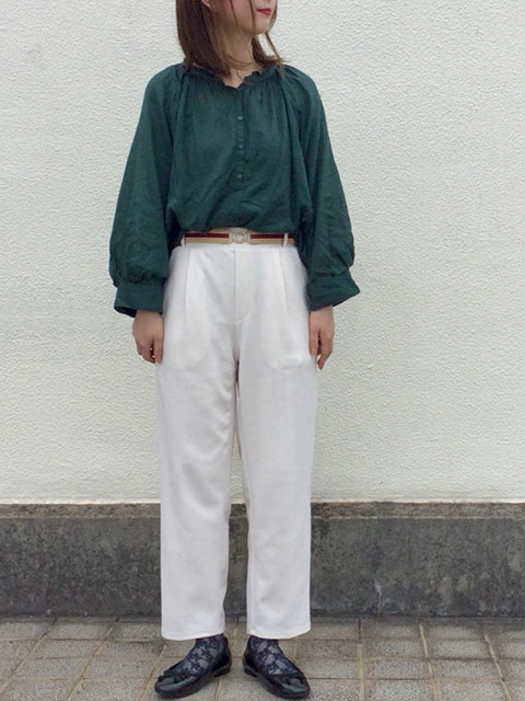 深グリーンのギャザーブラウスを白パンツですっきりと着こなしたガーリーカジュアルスタイルのコーデ画像
