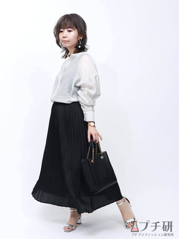 白シアーシャツ×黒ロングプリーツスカートでエレガントなモノトーンスタイルの画像
