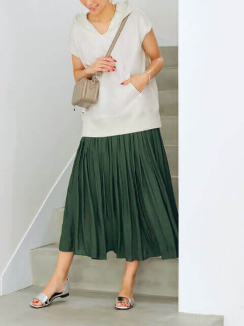 白ノースリーブフーディーに深グリーンギャザースカートを合わせたこなれたMIXスタイルの画像